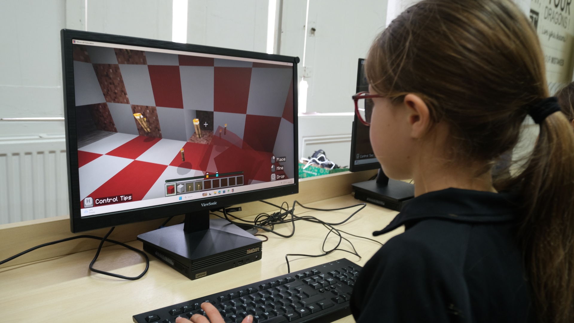 A student builds a red-and-white room in Minecraft Education.