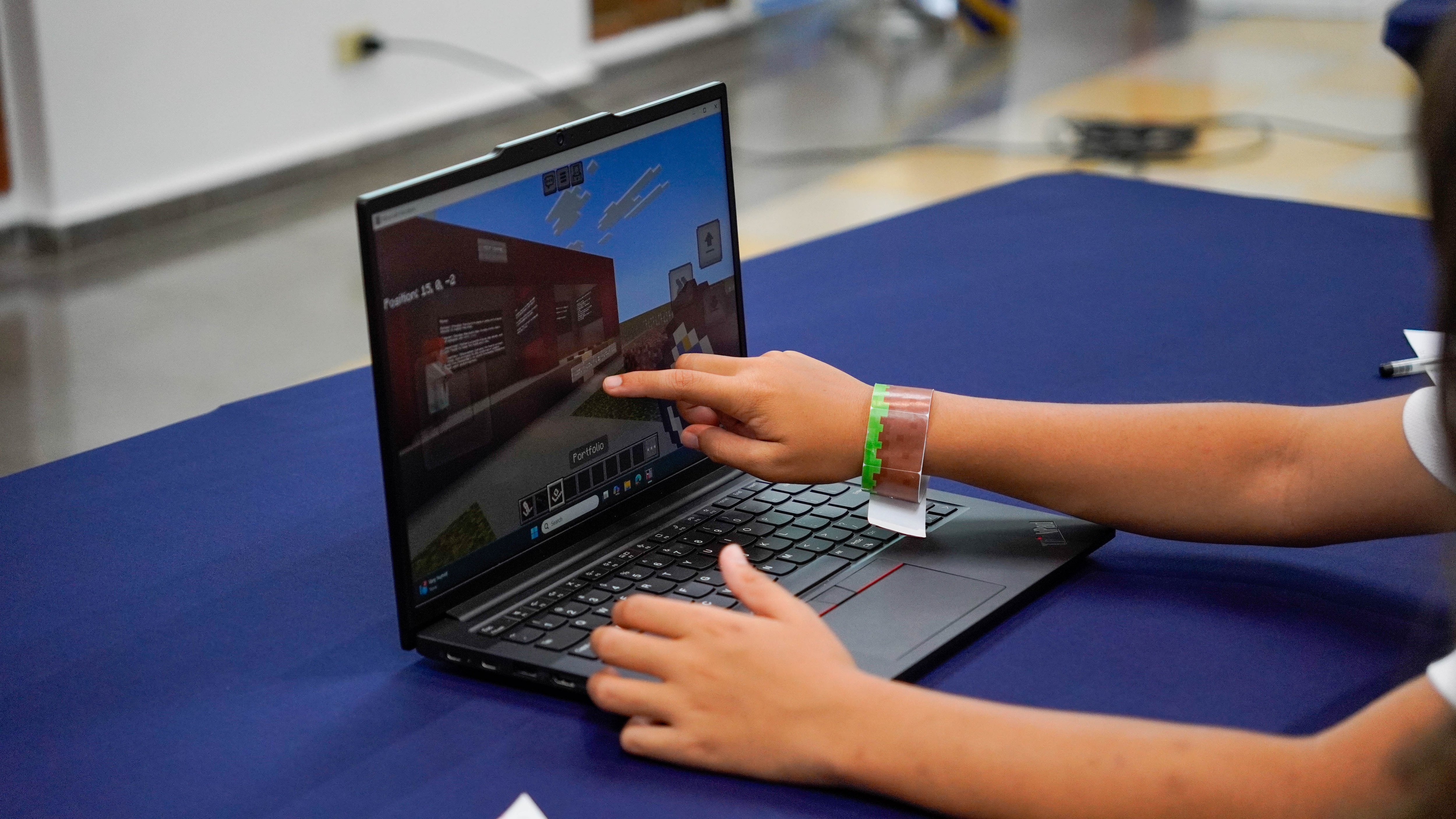 Student uses a laptop to play Minecraft during a classroom activity.