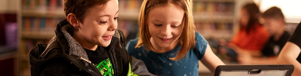A young boy and a young girl looking at a screen