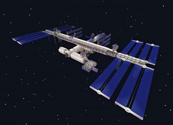 The image shows a digital rendering of the International Space Station against a starry black background, highlighting its solar panels and modular structure.